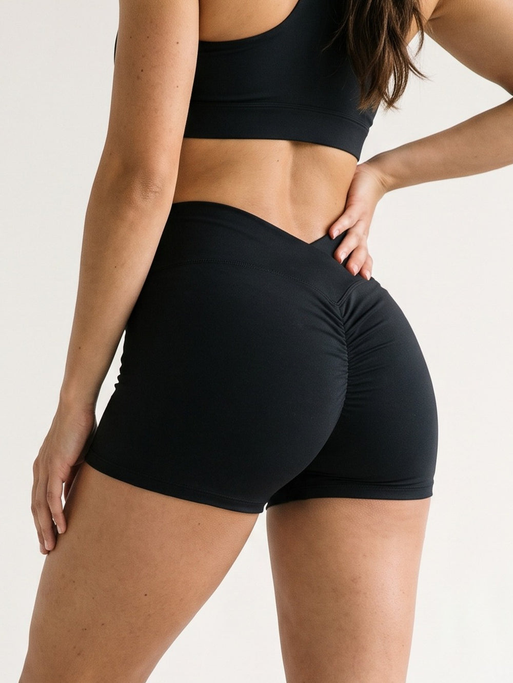 Black · Flow Curve Shorts noir, gros plan 3/4 dos sur la ceinture en V et le scrunch