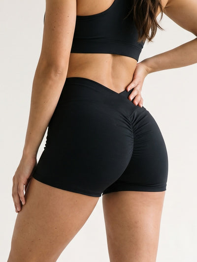 Black · Flow Curve Shorts noir, gros plan 3/4 dos sur la ceinture en V et le scrunch