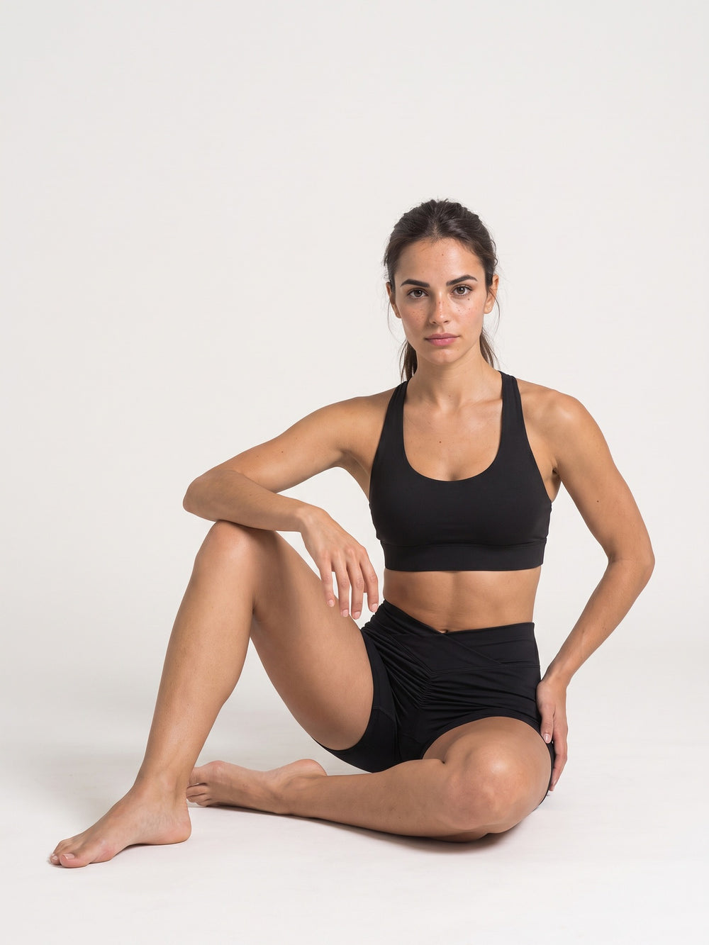 Black · Flow Curve Shorts noir, assise au sol genou relevé